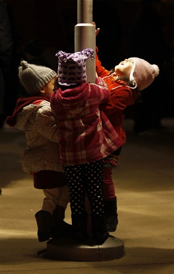 Children climbing on a lamp post