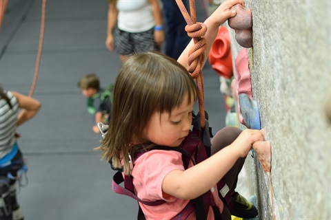 A student climbs during a children's climbing class.