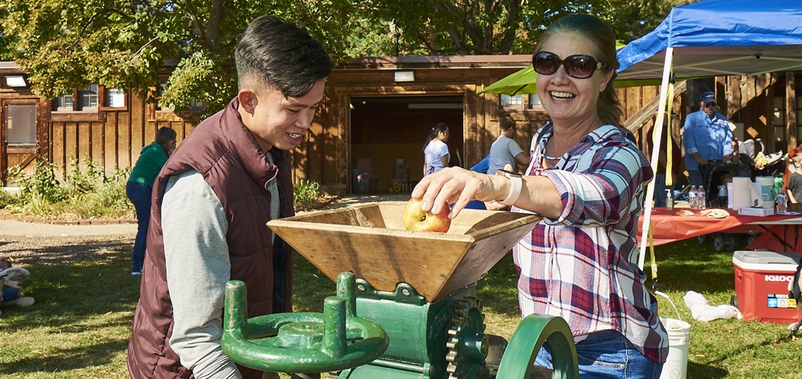 Two people press cider.