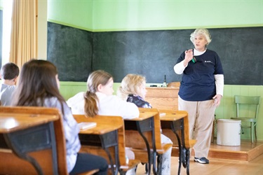 volunteer speaking in schoolhouse