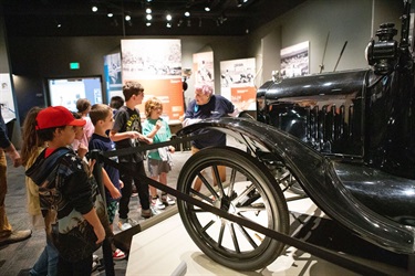 Volunteer teaching about an old car