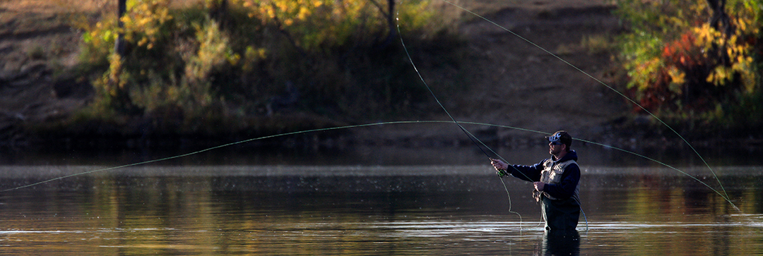 A fly fisher casts the line in Bear Creek Lake Park