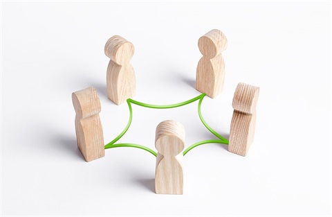 Five wooden stick people connected by a green string
