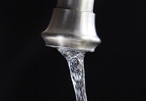 Sink faucet with running water.