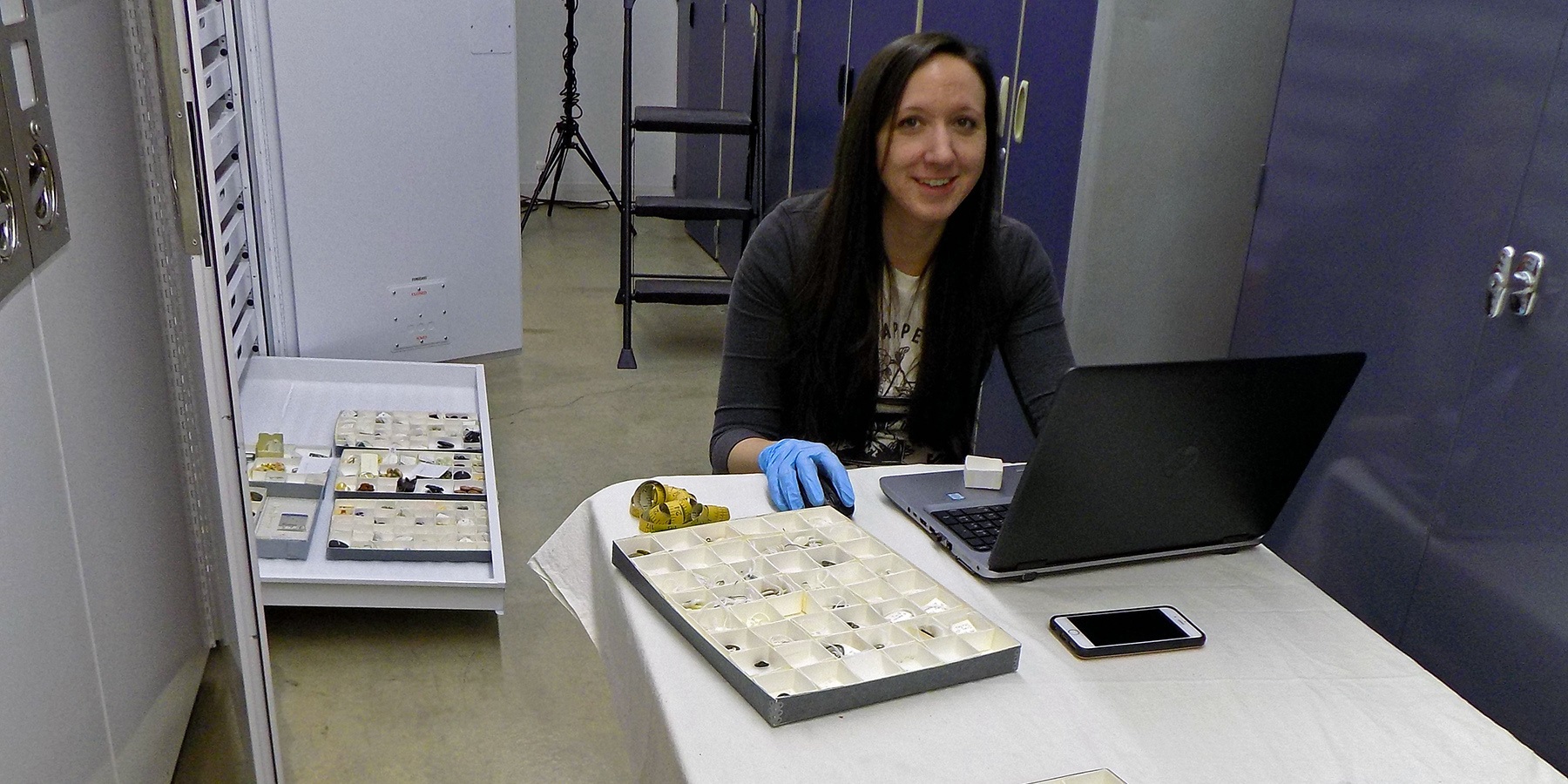 A volunteer catalogs items on a laptop.